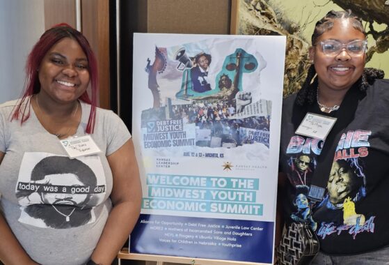 two teenage girls attending a conference standing by a poster