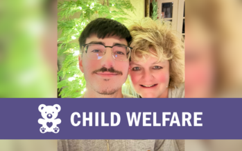 Patti Koraleksi and her adult son, Nick, smile for a photo in front of a Christmas tree.