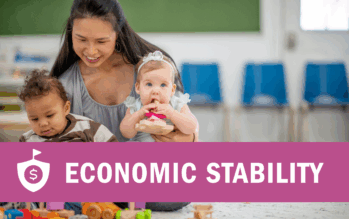A female child care worker of Asian descent sits on the floor as she plays with and entertains two small children. The babies are playing with colorful blocks and toys as they discover new things around them.