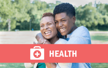 Handsome African American teenage boy hugs his mom outdoors.
