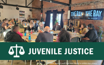 Adults and youth sit around a table at Voices for Children in Nebraska's Youth Accountability event at The Bay in Lincoln.