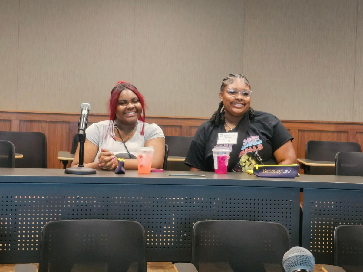 Two Black teenage girls sitting at a table at the Midwest Youth Debt Free Justice conference.